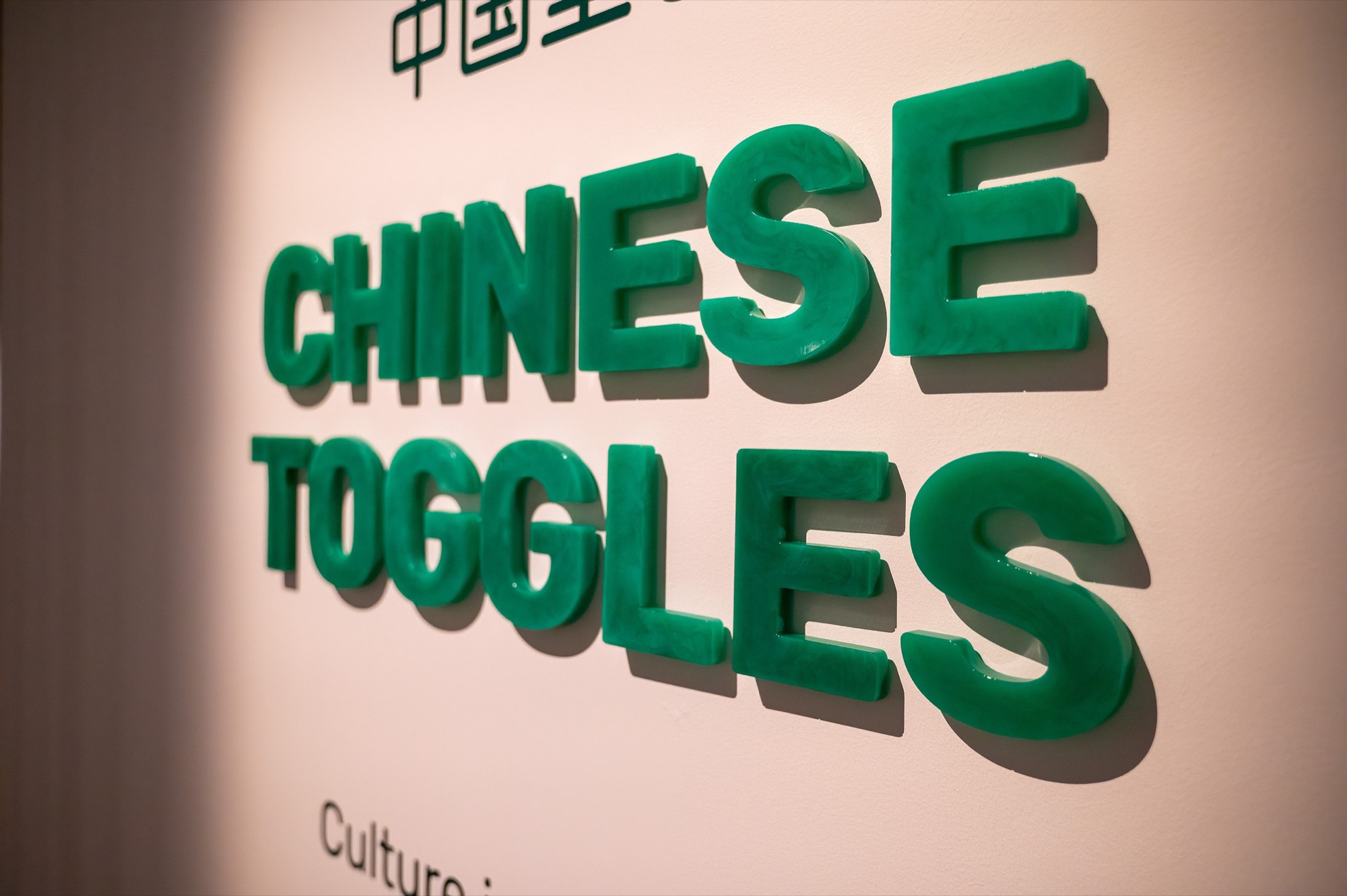 Close view of translucent green cast-resin Chinese Toggles dimensional lettering.