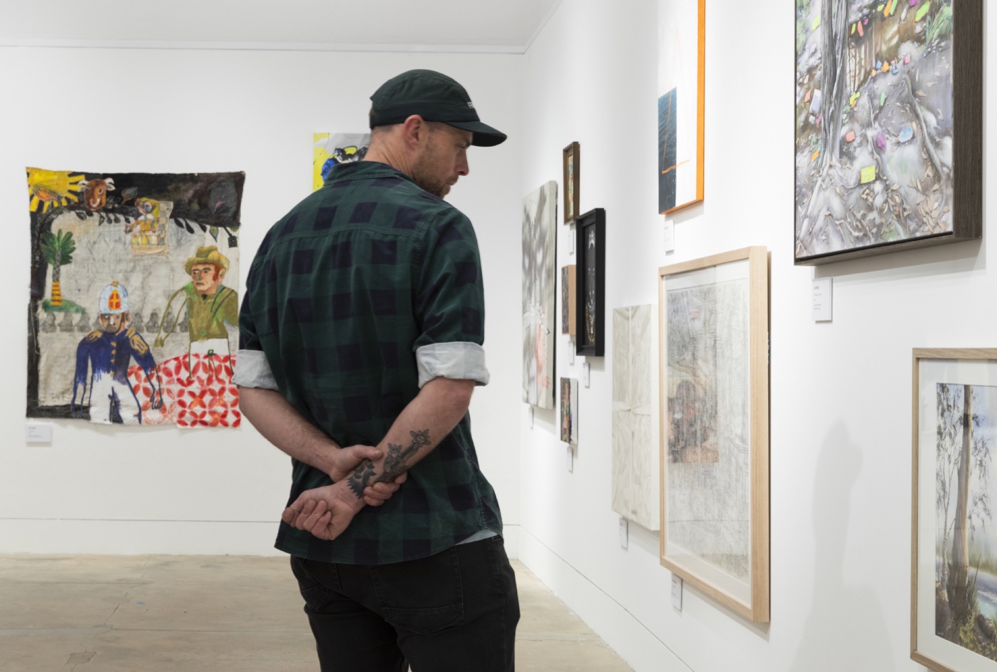 Visitor viewing artworks and individually printed artwork labels at the Waverley Art Prize.